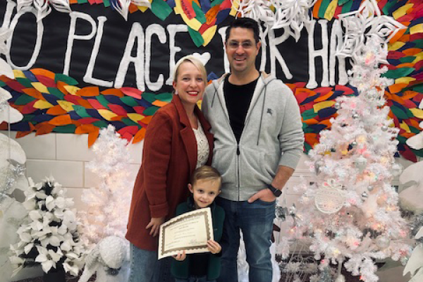 Family standing in front of decorations.