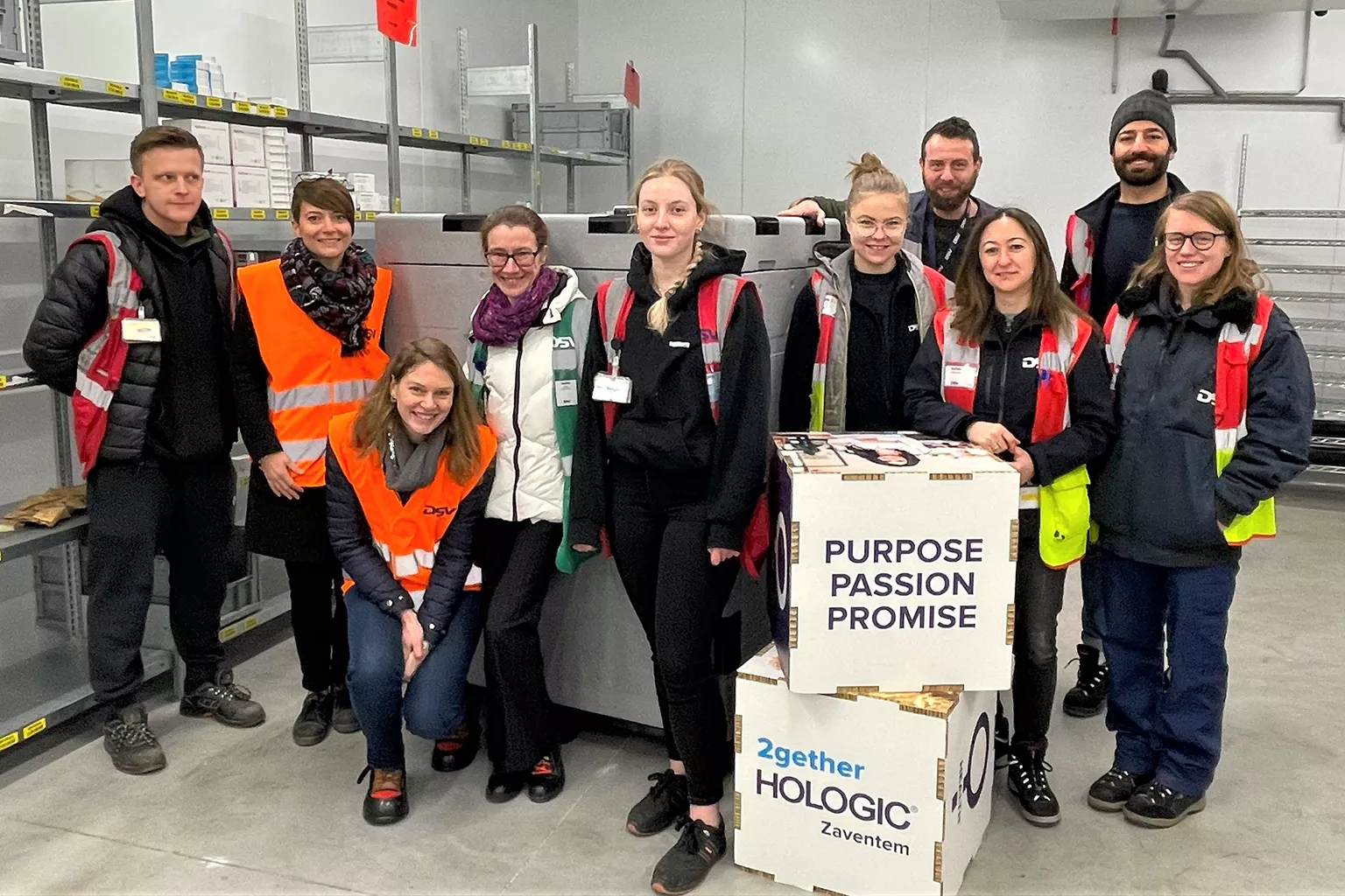 Group of employees in warehouse setting.