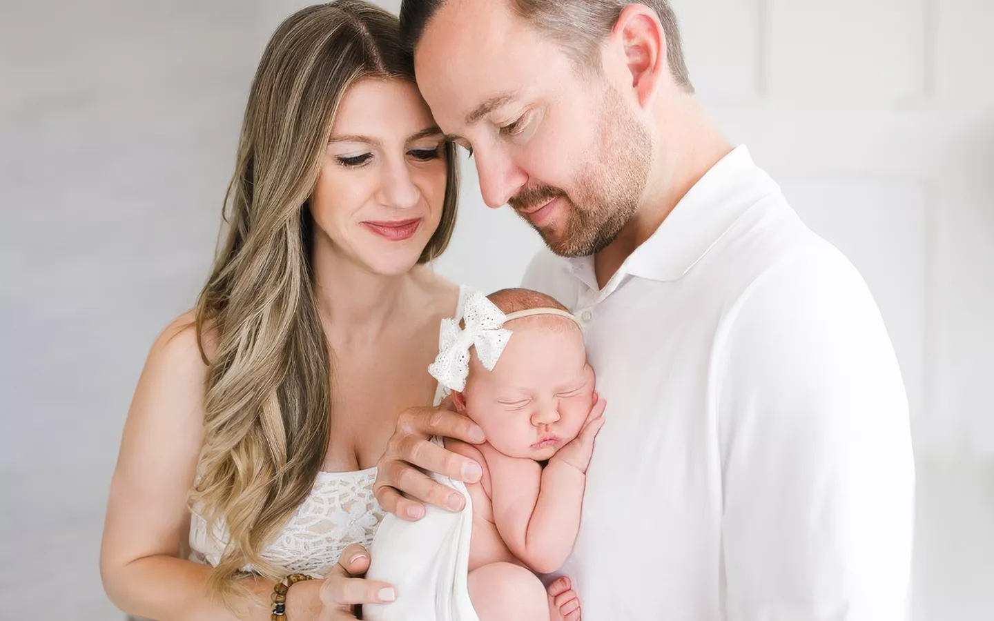 Mother and Father hold their infant baby.