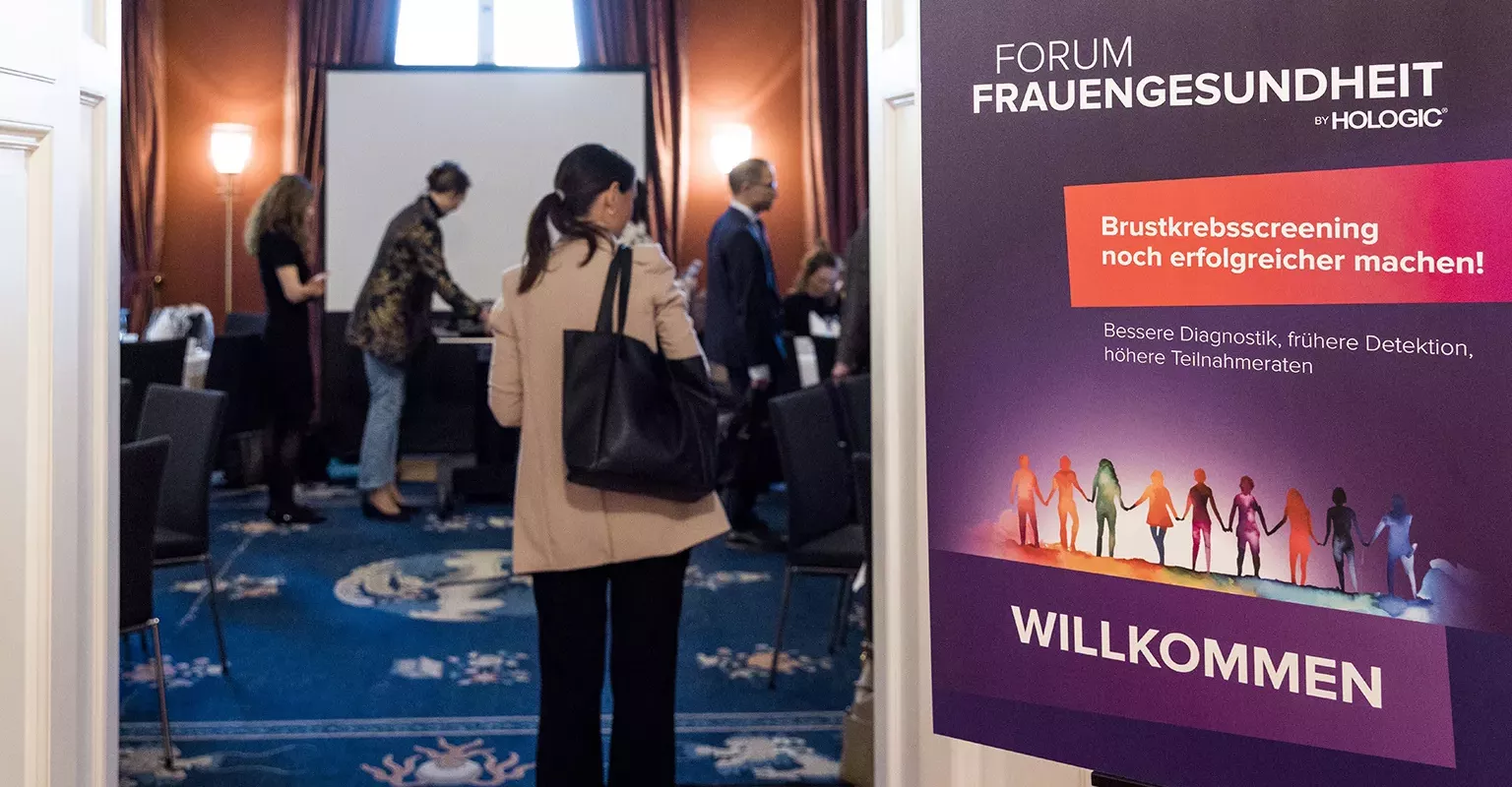 Woman walks into entrance of conference room.