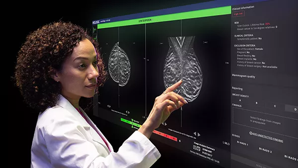 Technician interacting with monitor display in dark room