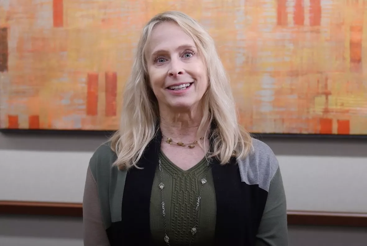 Individual photo of woman smiling inside an office space.