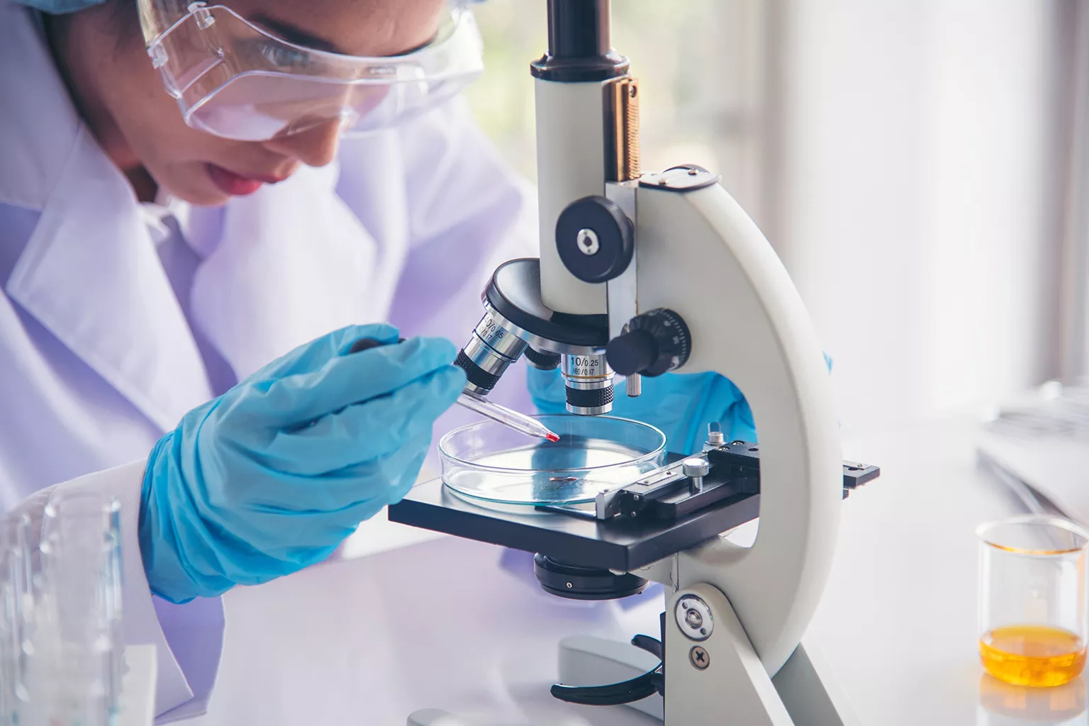 Lab technician operating a microscope