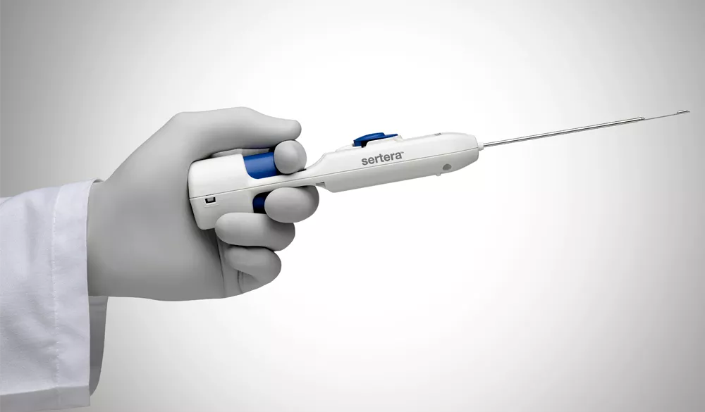 Gloved hand holding medical device on white background