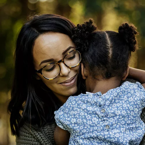 Photo of woman hugging her young child.